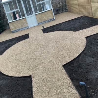 Pouring gravel on to garden landscape path